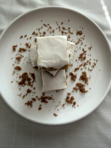 Maple Brown Sugar Bars topped with white maple icing on a plate